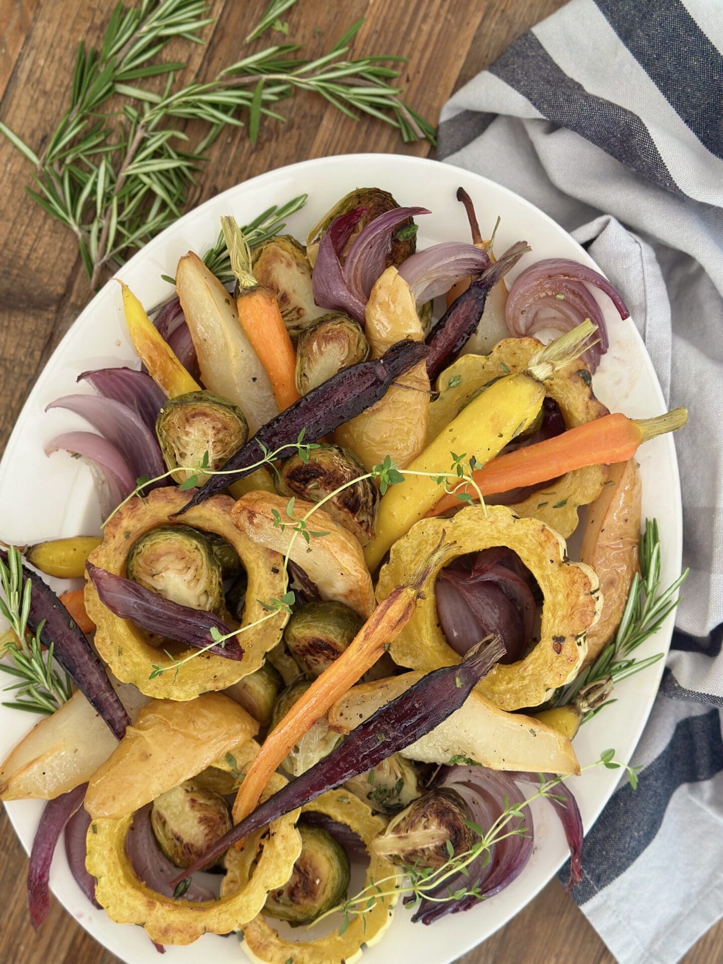IMG_9432 A platter of Maple Butter Roasted Vegetables with Pears is seen from above surrounded by fresh herbs