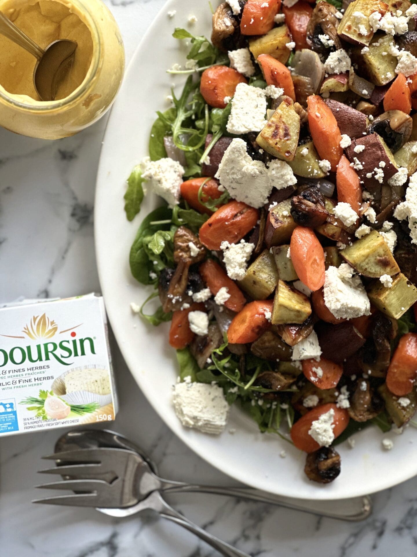 IMG_6969 A platter of Warm Roasted Vegetable Salad with Boursin is seen from above, surrounded by a package of Boursin cheese and an open jar of dijon mustard.