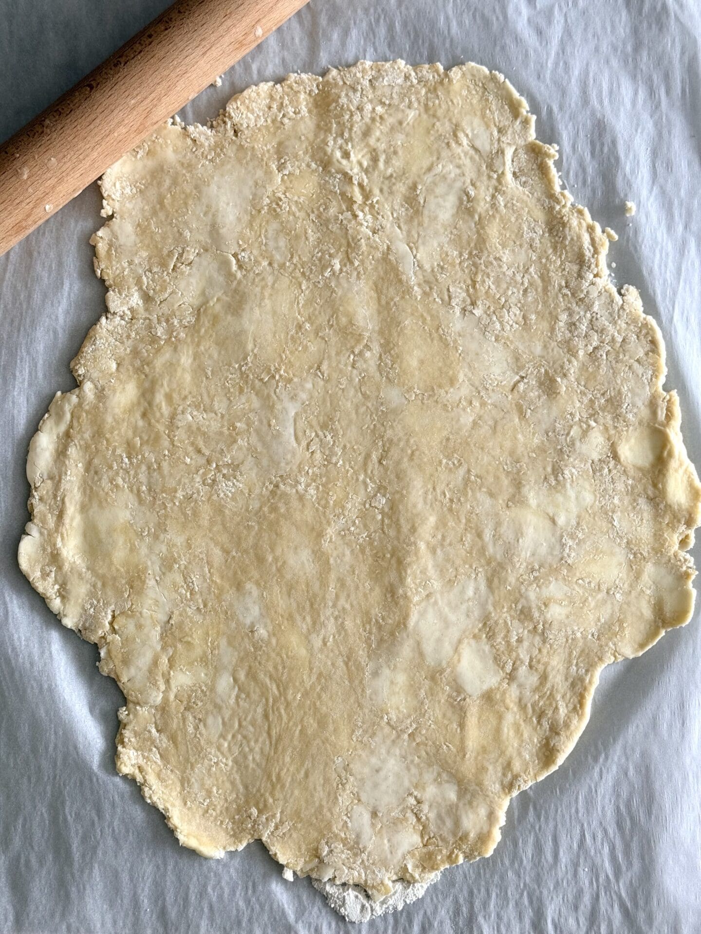 IMG_8418 The chilled pastry for butter tarts is rolled out on a sheet of wax paper. Pieces of butter are still visible in the dough.