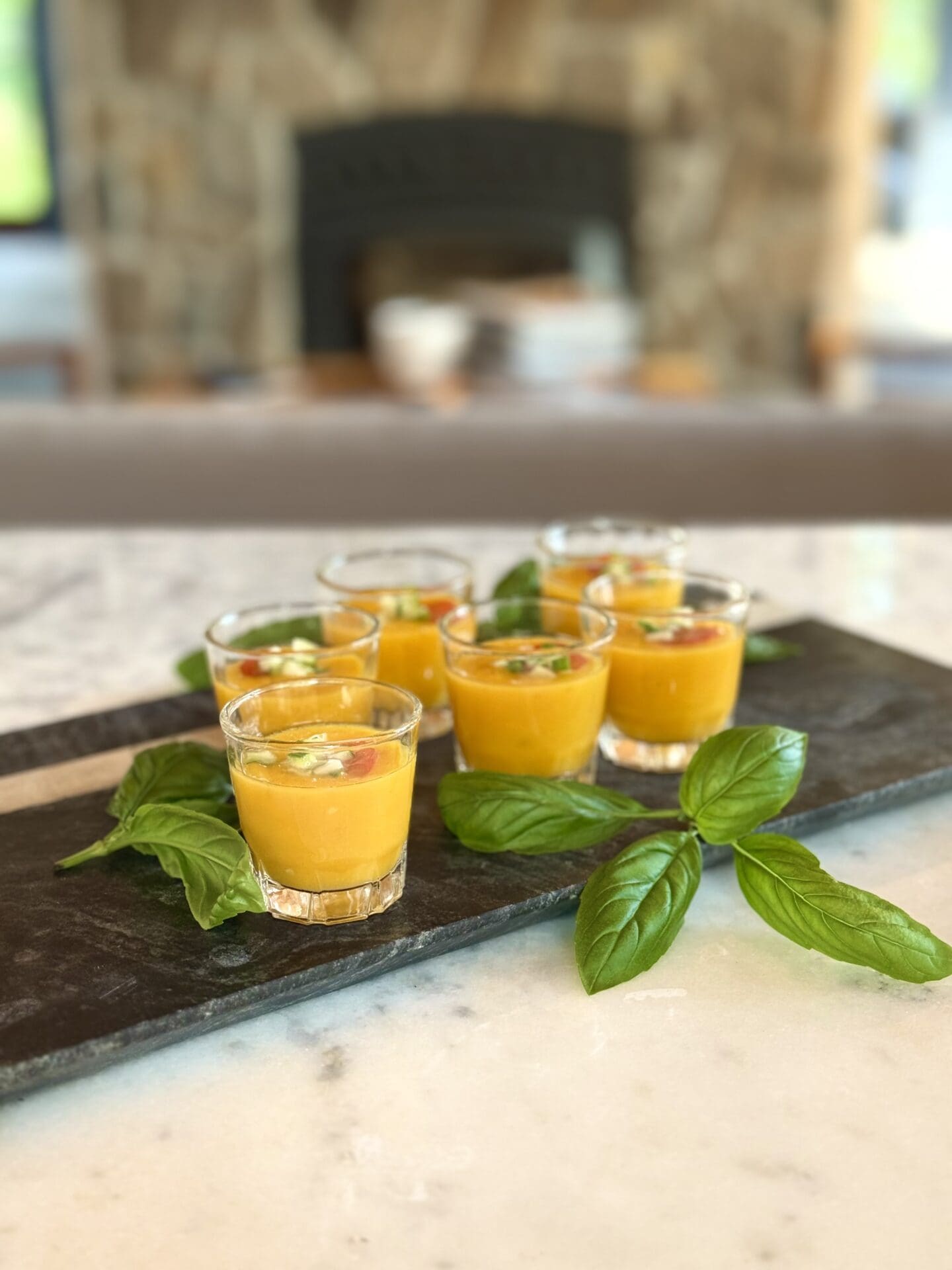 IMG_9835 Small glasses filled with Yellow Tomato gazpacho sit on a tray, ready to be served at a cocktail party.