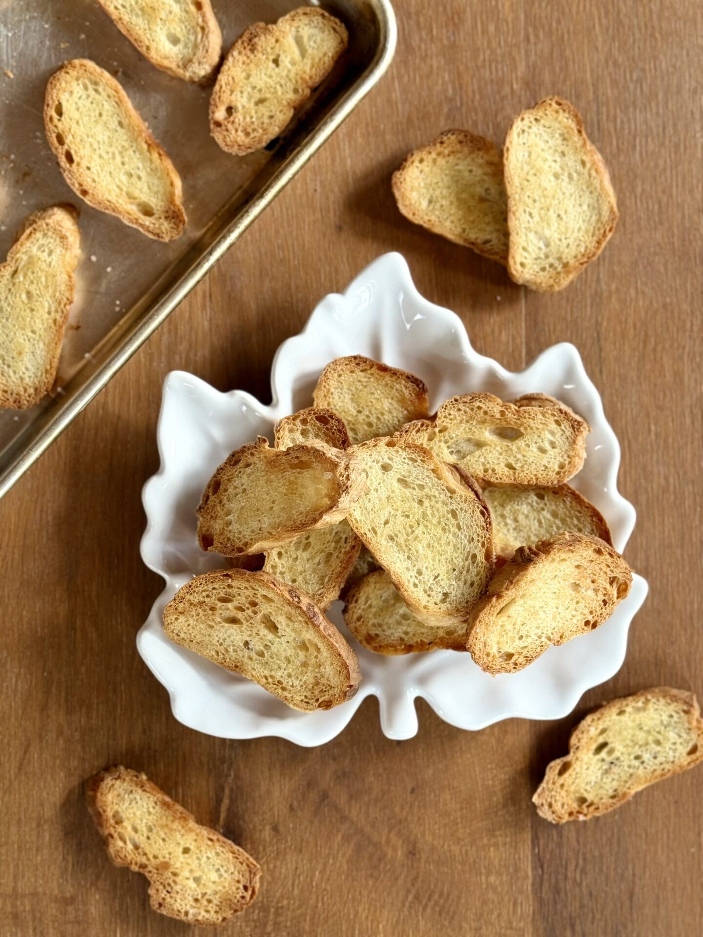 A maple leaf shaped plate holds golden crostini.