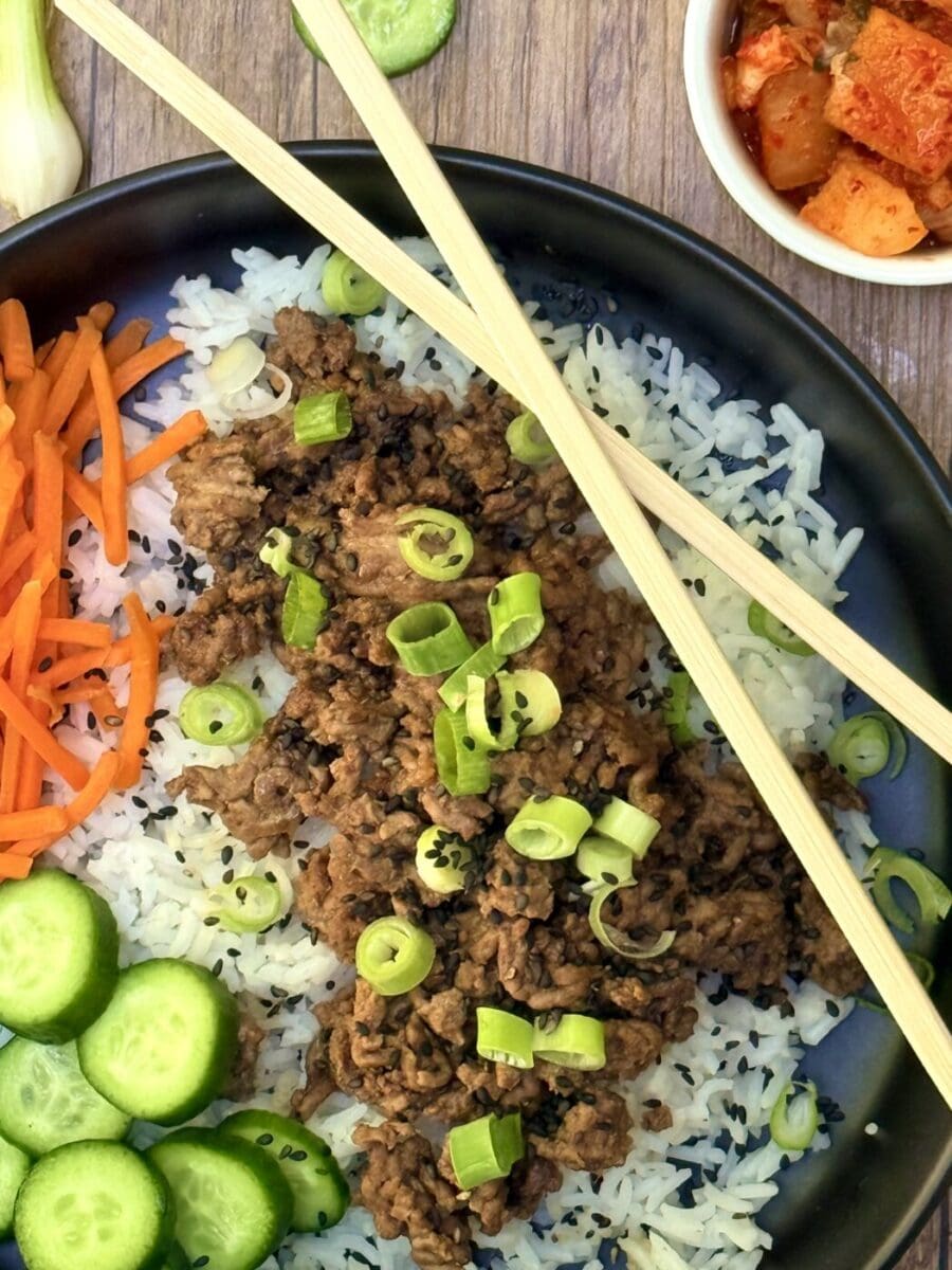 Korean Ground Beef Bowl close up A Korean Ground Beef Bowl meal is seen close up, showing the beef in a rich sauce and the vibrant and crunchy vegetables all served over a bed of fluffy rice.