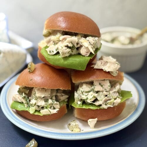 Three golden buns are seen overflowing with Greek Yogurt Dill Pickle Chicken salad.