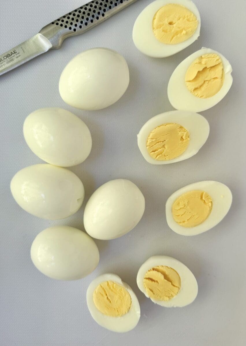 Perfectly cooked hard boiled eggs are seen being cut for devilled eggs.