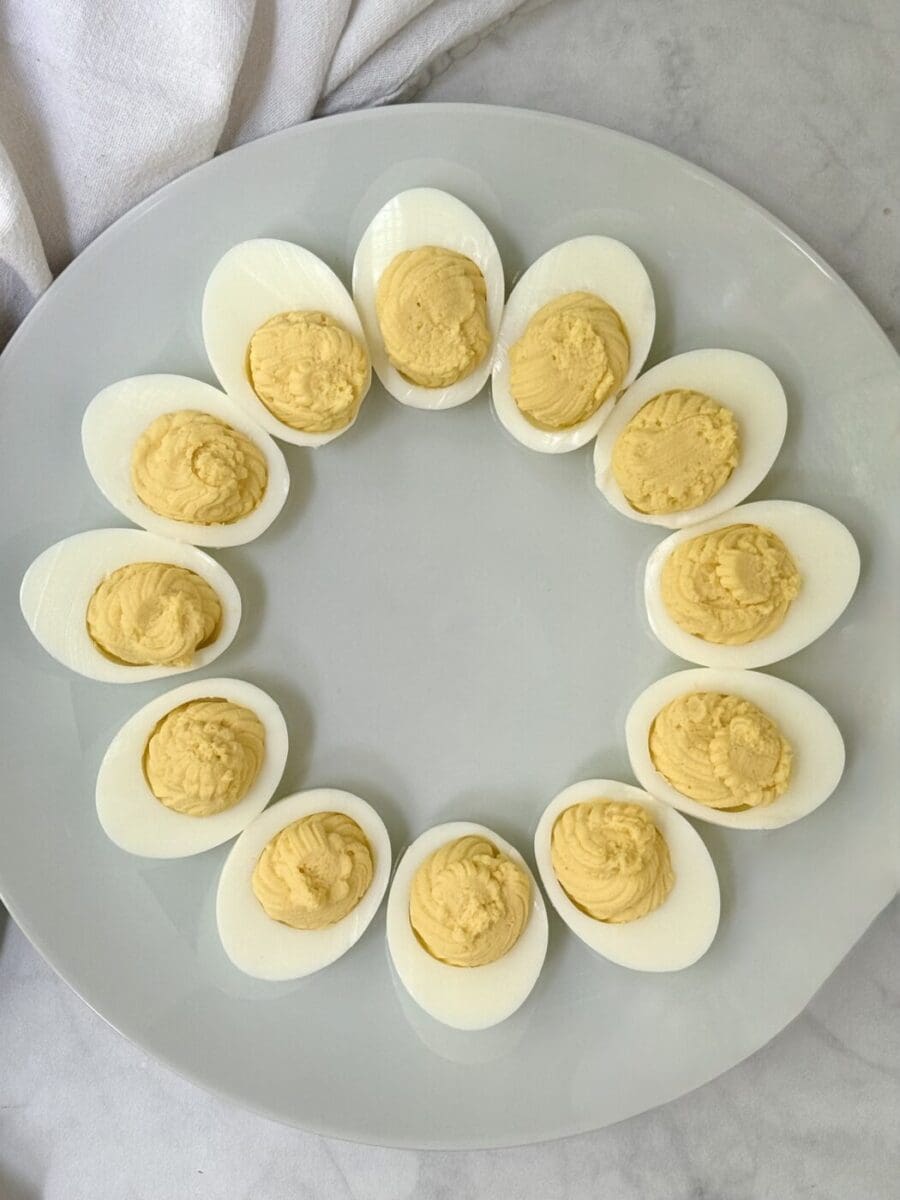 Plain deviled eggs are arranged in a circle and seen from above.