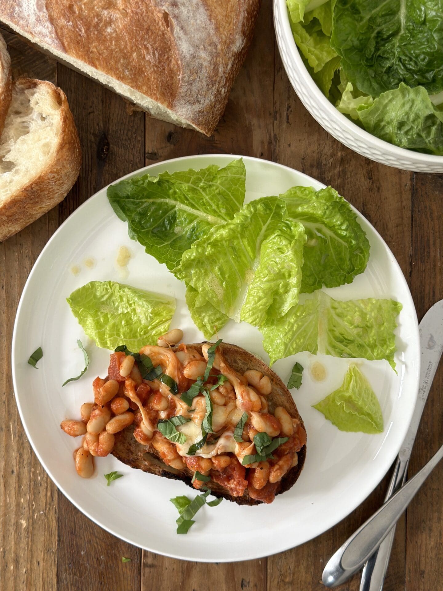 IMG_1065 A plate is seen from above with Easy Cheesy Beans on a slice of garlic toast with a side of green salad