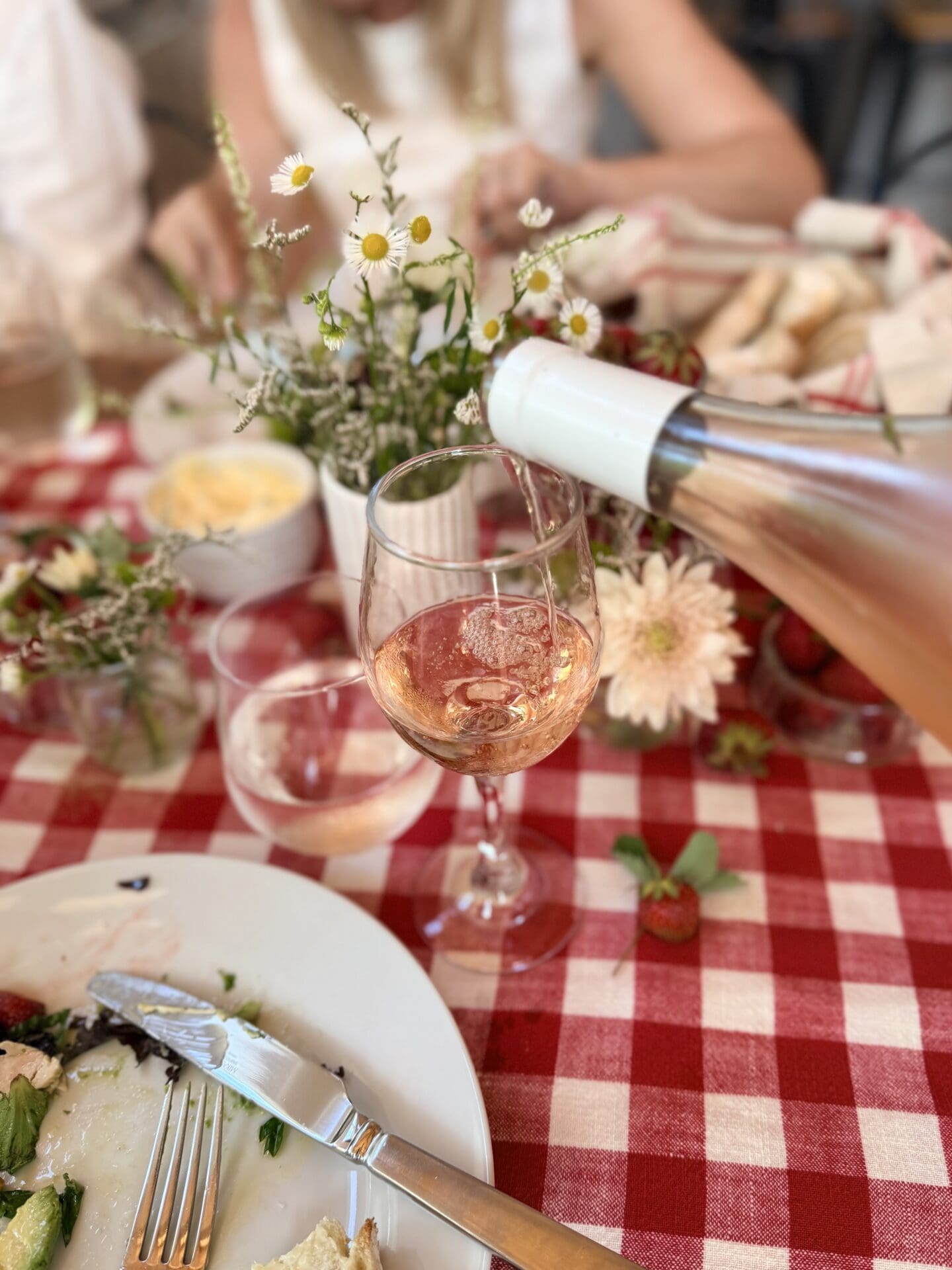 IMG_9540 A bottle of rosé wine is poured into a glass at the strawberry social lunch.